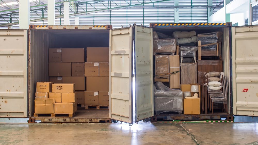 Container packed with wrapped furniture and cartons in storage