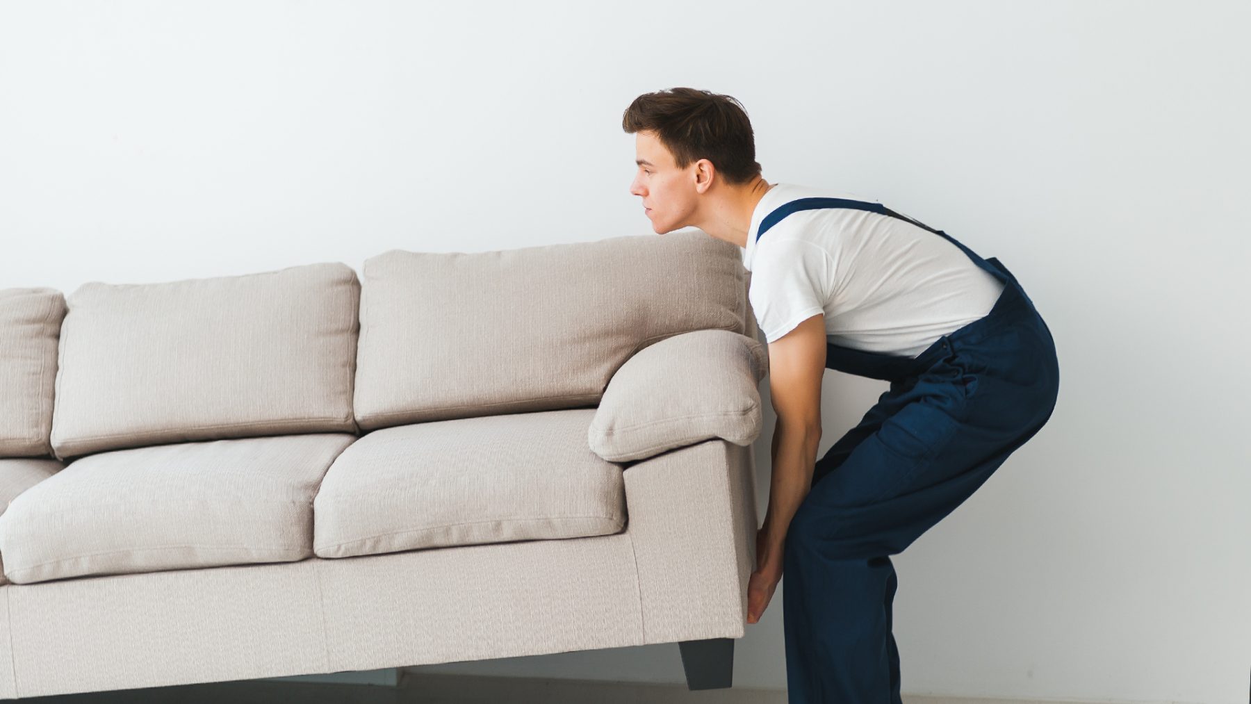 Mover carefully lifting a sofa