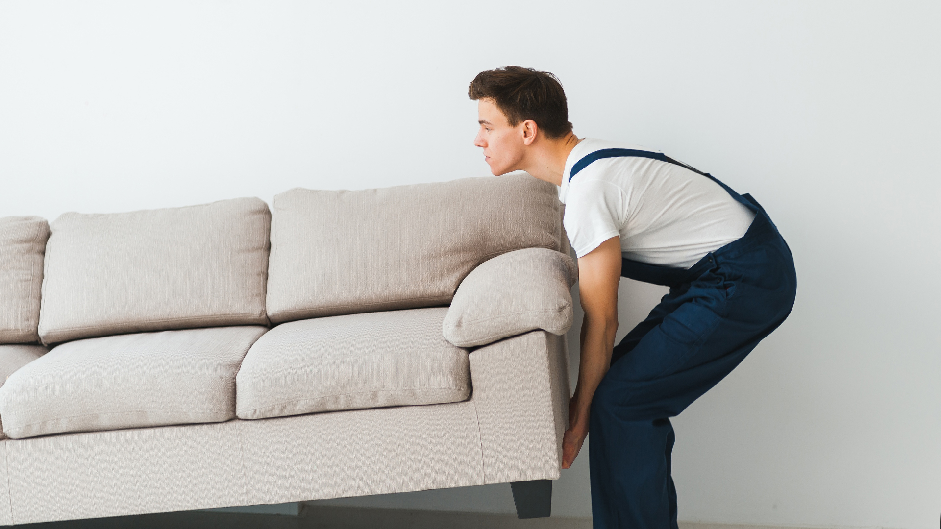 Mover carefully lifting a sofa