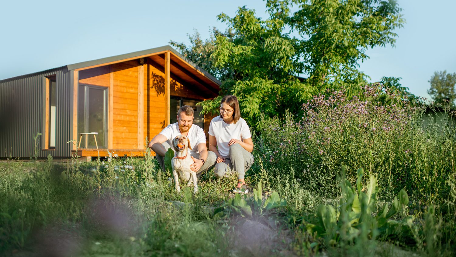 Couple and their dog outside their new home
